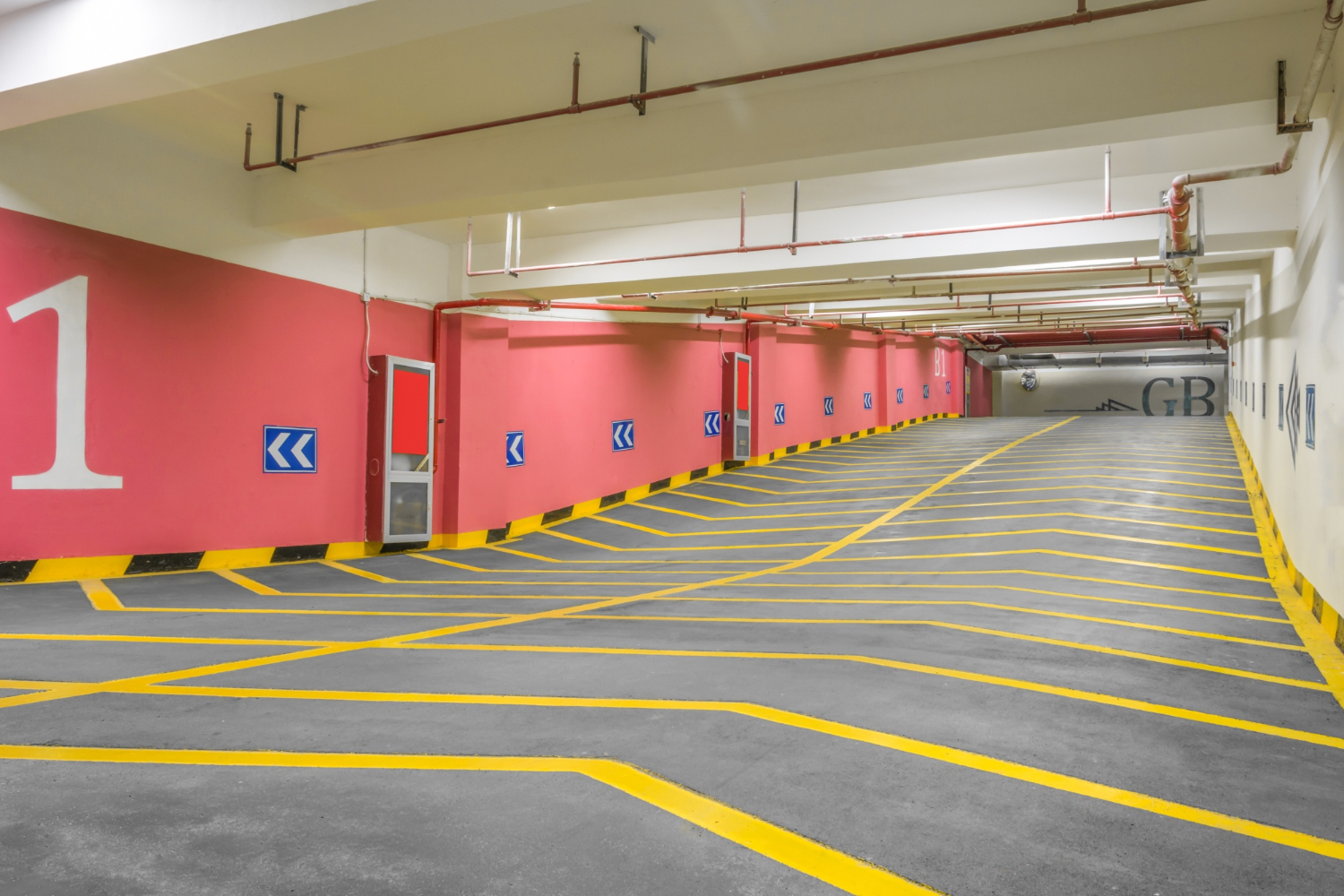 2354 Indoor parking garage with yellow lines, pink walls, and a large white number 1 painted on the left wall.